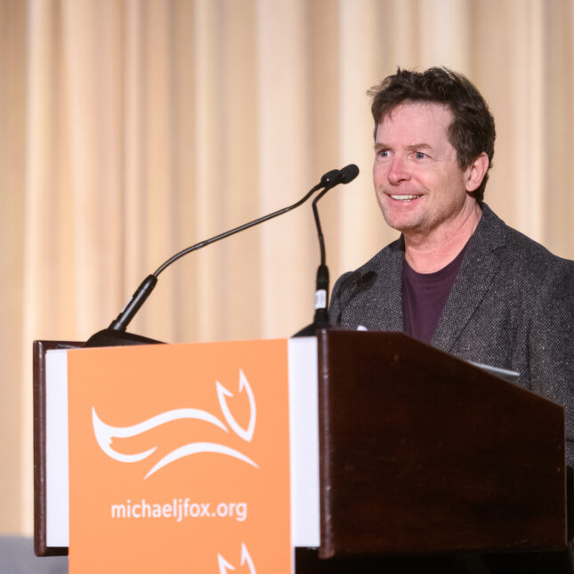 Michael J. Fox stands at a podium. -- First Opinion coverage from STAT