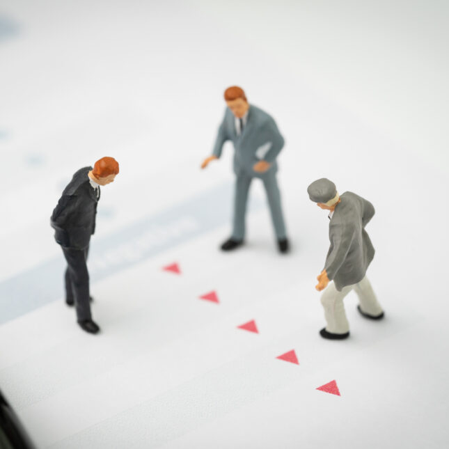 Miniature people figurines standing in a group looking down. -- health tech coverage from STAT